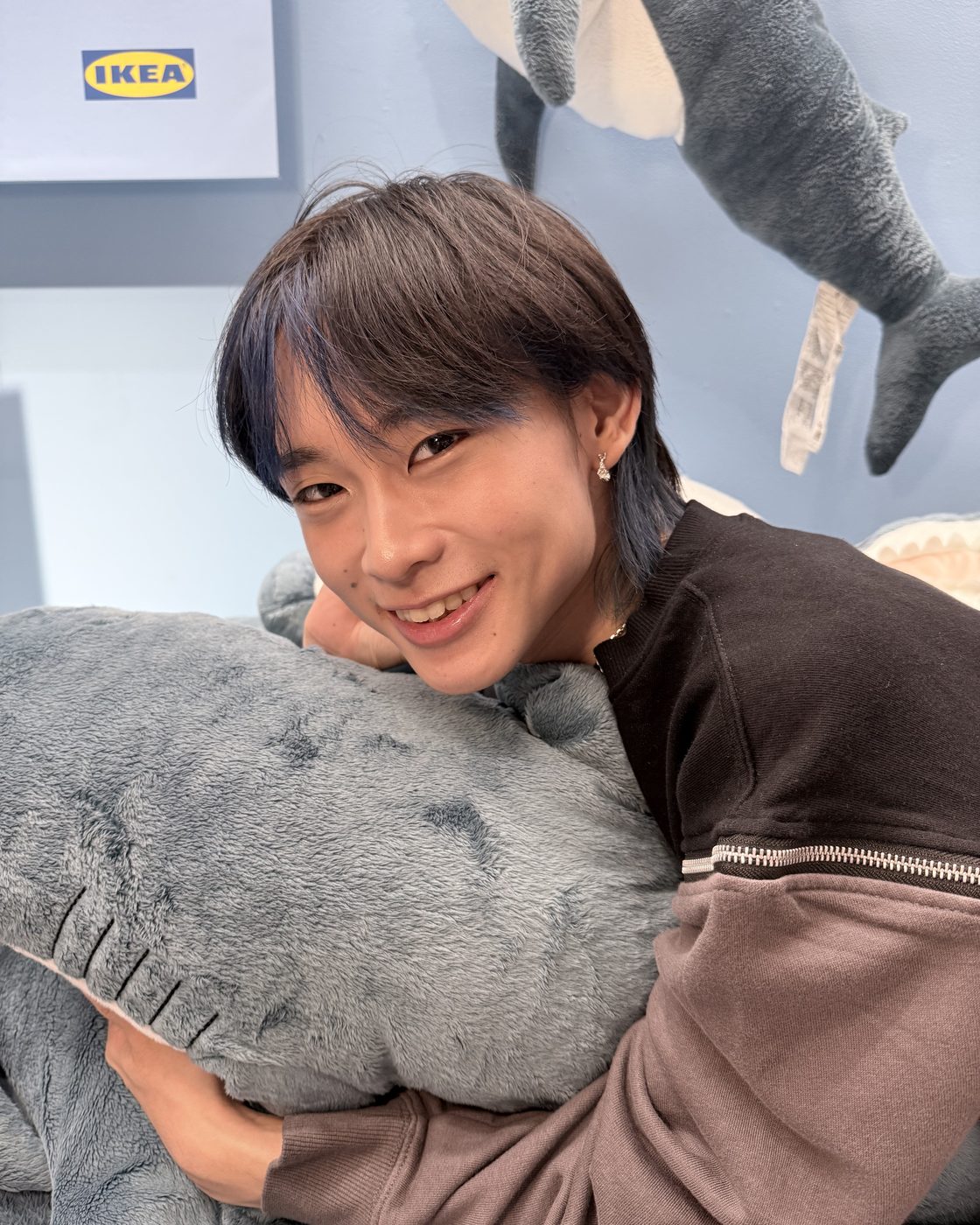 Arya Nathan Bara, smiling while hugging a plush shark